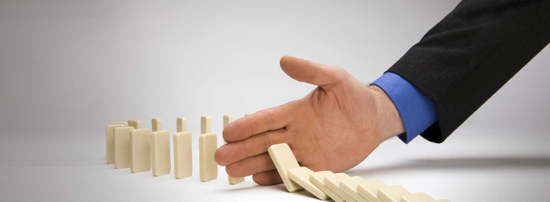 Crisis management planning is like this hand blocking more dominoes from toppling